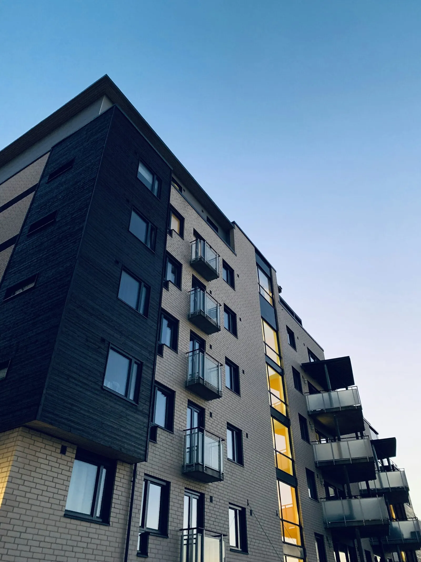 Fachada de un edificio residencial de varios pisos bajo cielo despejado